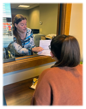 an image of a staff member assisting a member of the public with civil documents