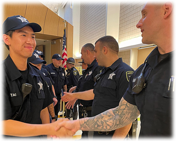 an image of a new Academy graduate shaking the hand of an instructor